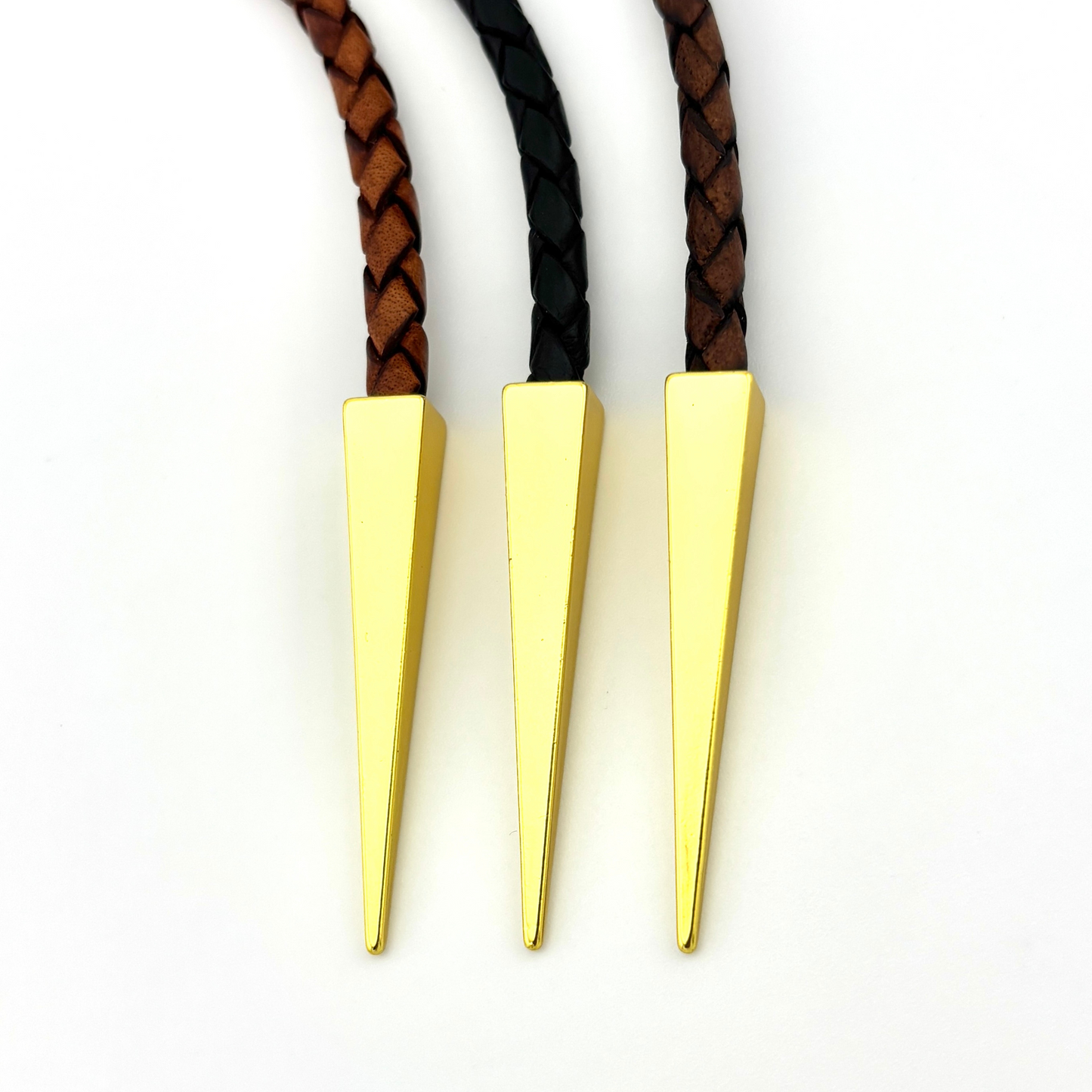 Three braided leather necklaces with gold cone-shaped clasps on a white background